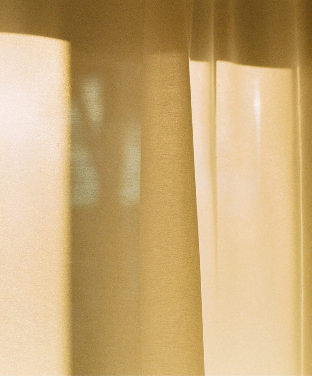 Warm sunlight filtering through sheer curtains